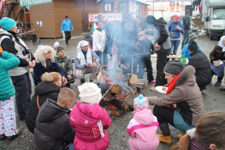 Uczestnicy pieką kiełbaski na ognisku